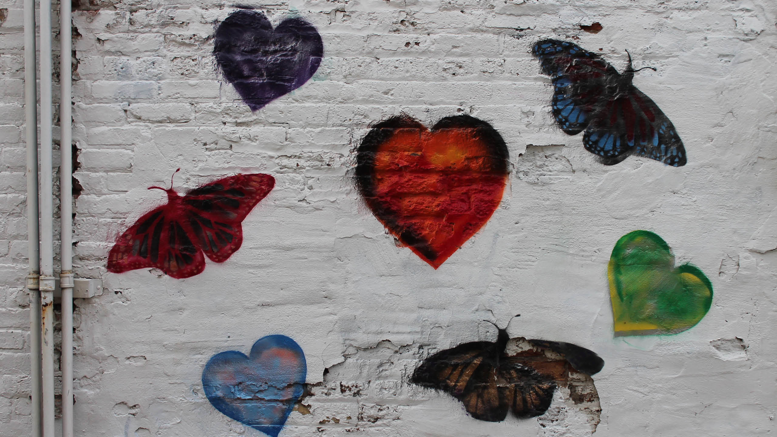 painted white wall with hearts and butterflies