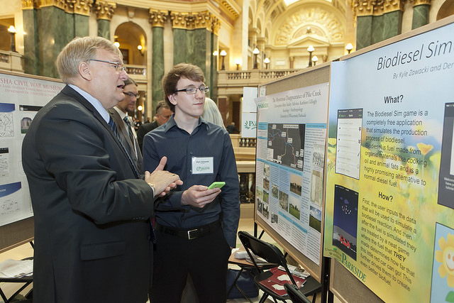 State Senator Van Wanggaard learns the Biodiesel Sim game from UW-Parkside student Kyle Zawacki (r)